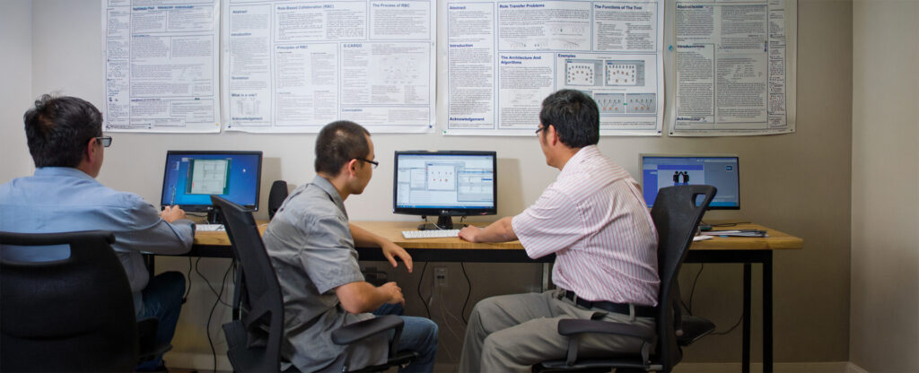 A student and a professor looking at a computer screen in the lab