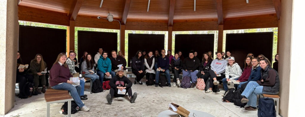 A group of students and professor at the outdoor classroom at Nipissing