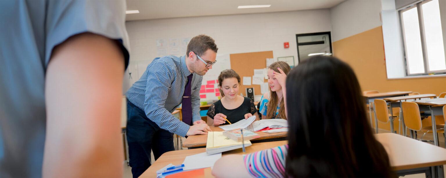 A teacher helping a student in a classroom setting