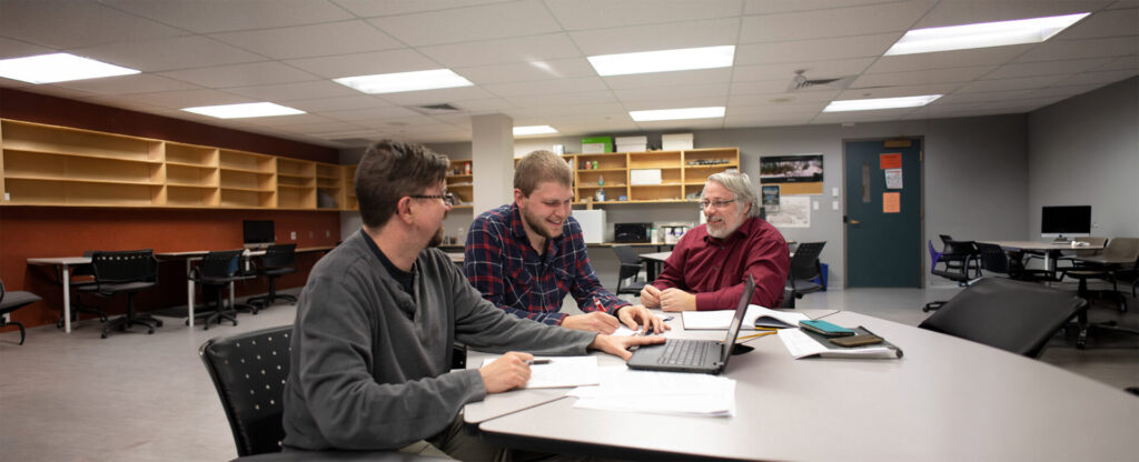 A student working with 2 professor in an office setting