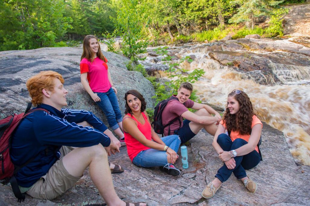 A group of students sitting at Duchesnay falls in North Bay