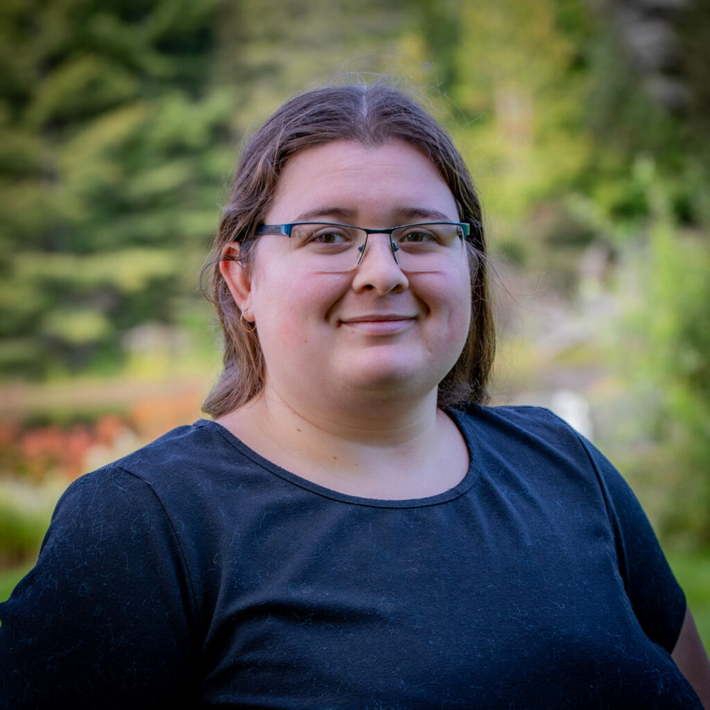 A woman in black shirt in front of the nature background