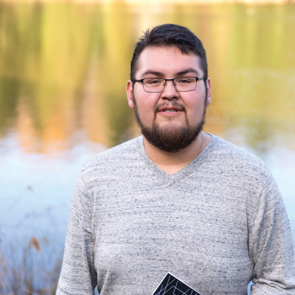 A student in grey top with the pond in the background