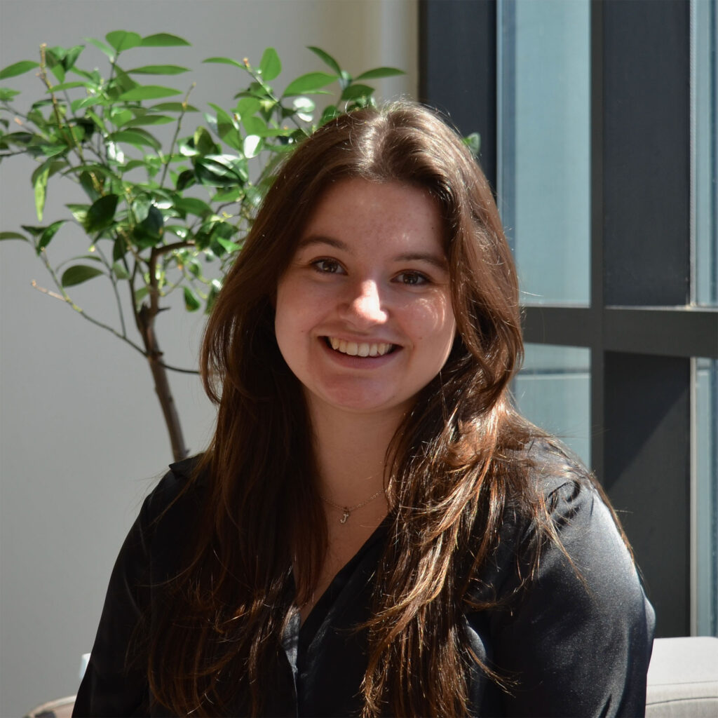 A female student in black top sitting in the sunshine in the library