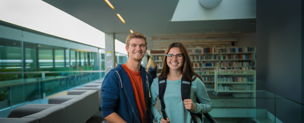 A female and male student in the library