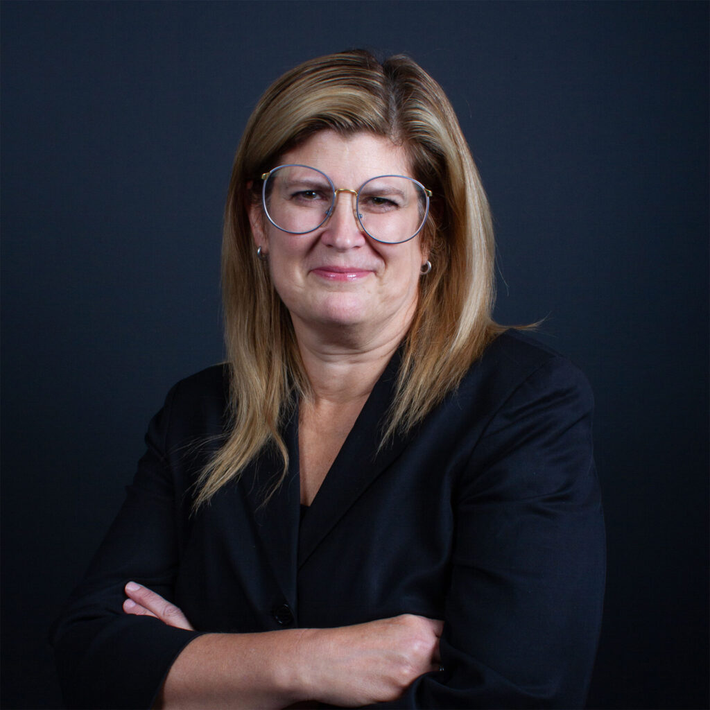 A professor in black clothing against a dark background