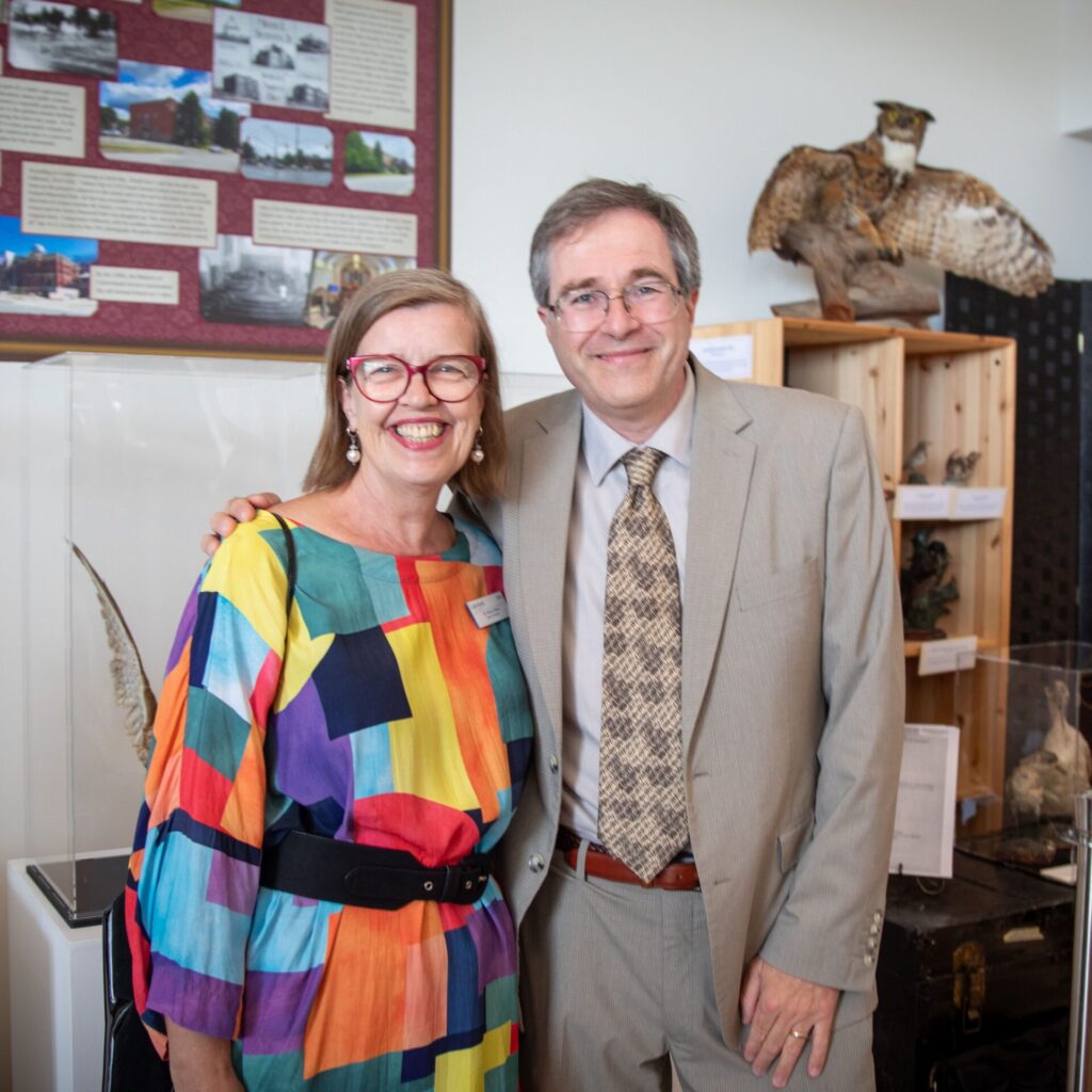 A female and male professors standing next to each other in an office setting