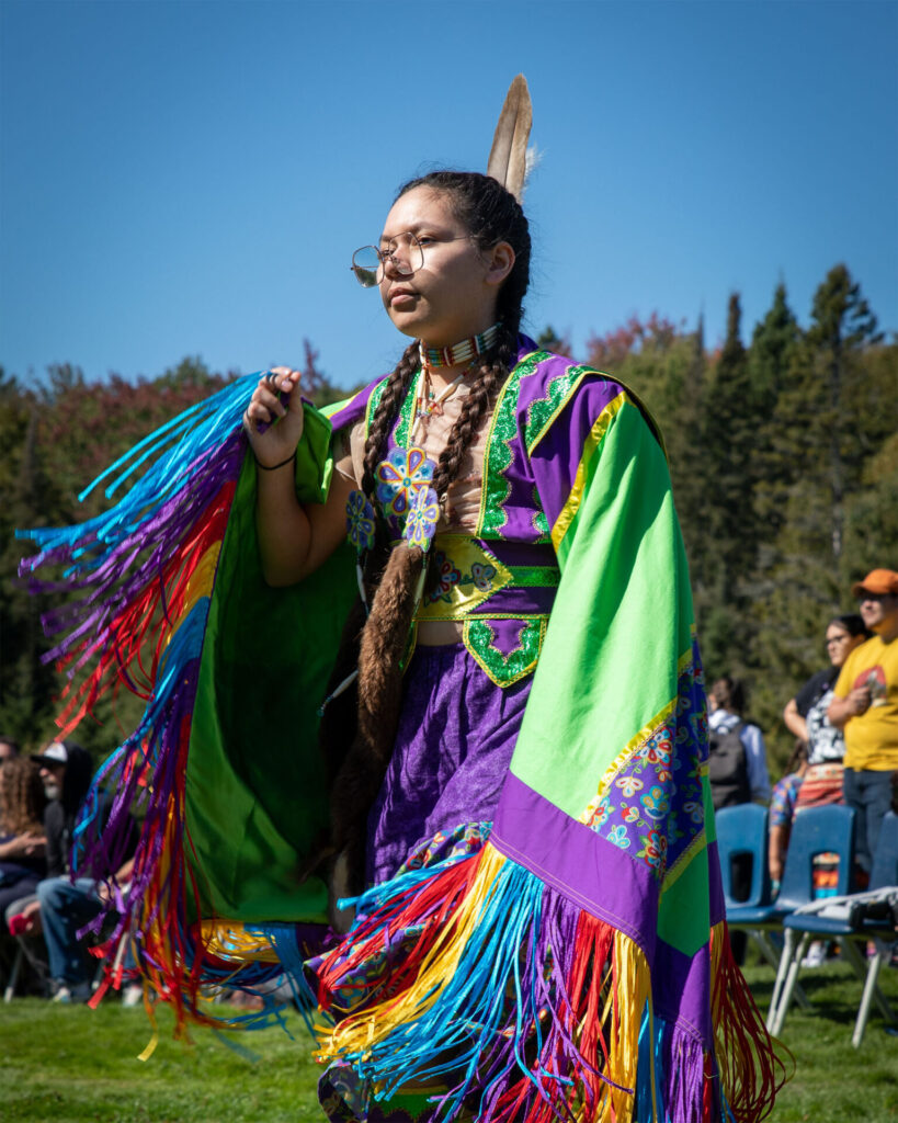 An Indigenous woman wearing traditional clothing in the Annual Pow Wow at Nipissing
