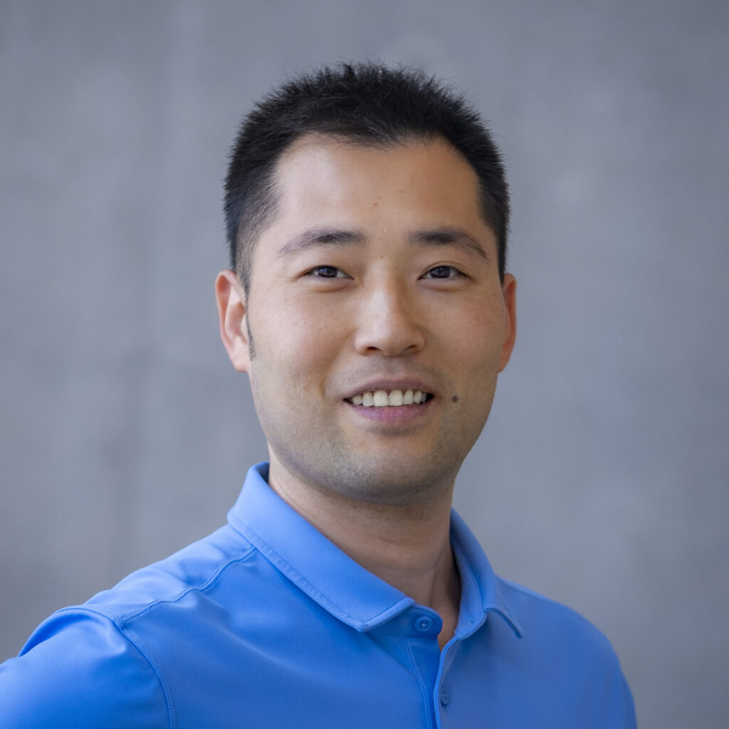A man in blue polo against a grey background