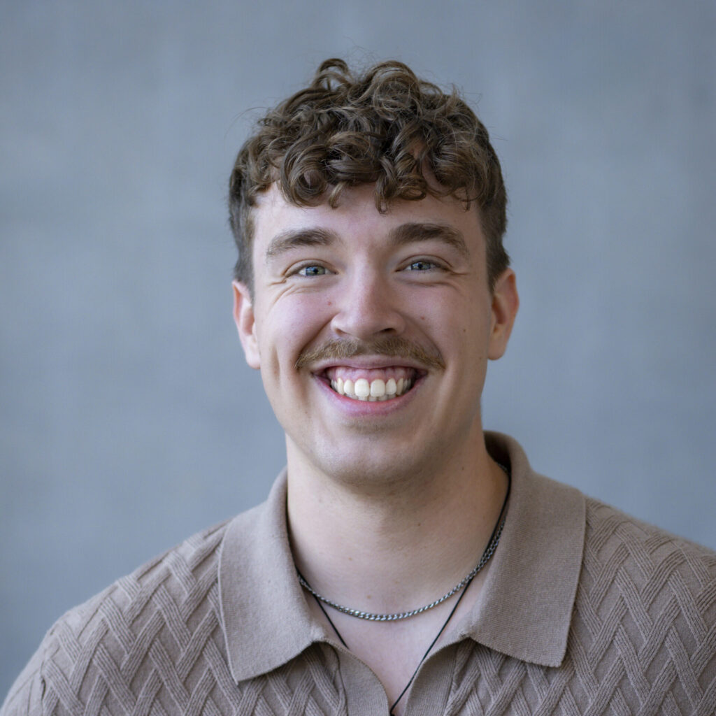 A man in beige top against a grey background