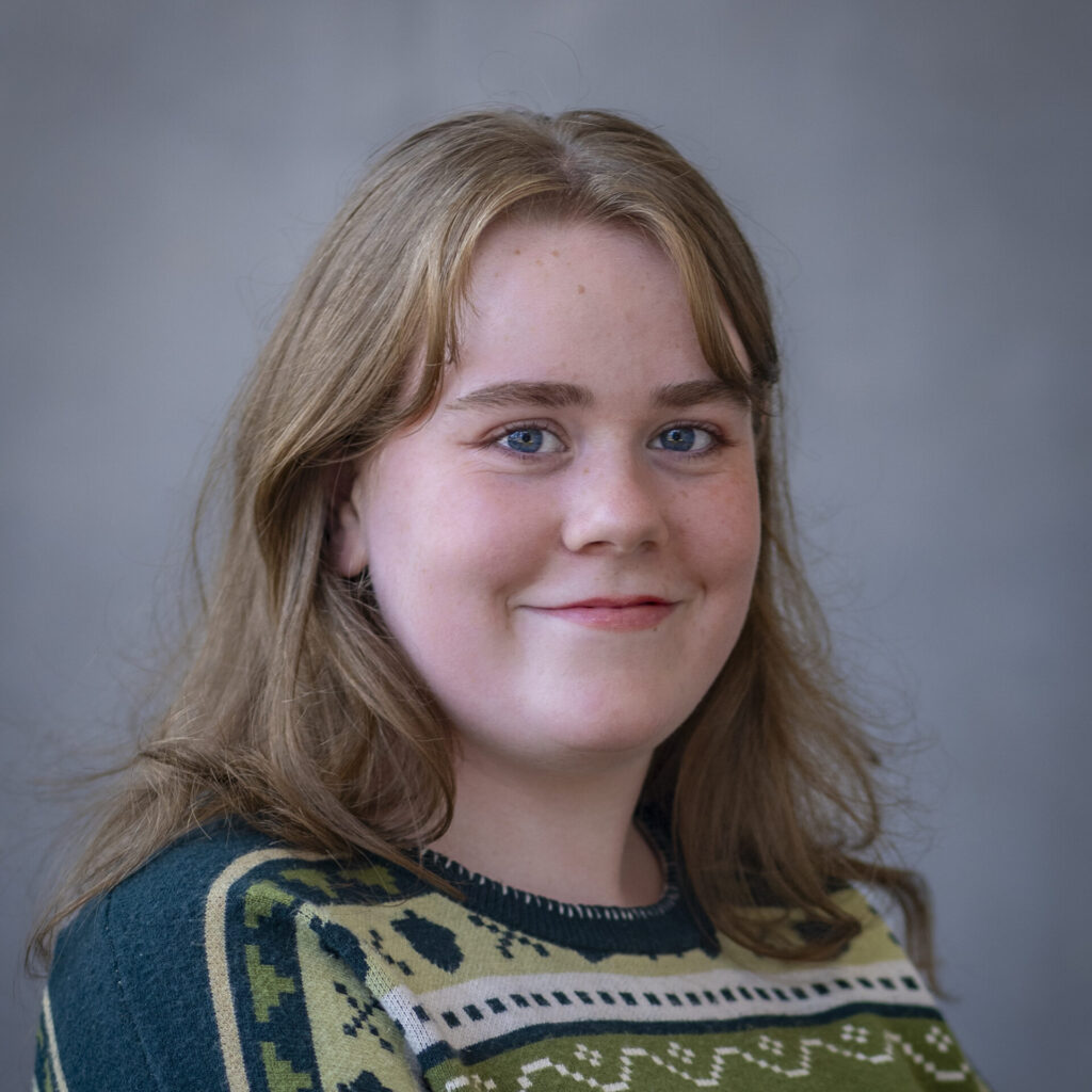 A woman in pattern sweater against a grey background